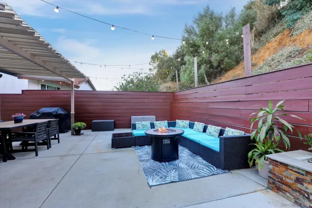 a backyard of a house with barbeque oven and outdoor seating