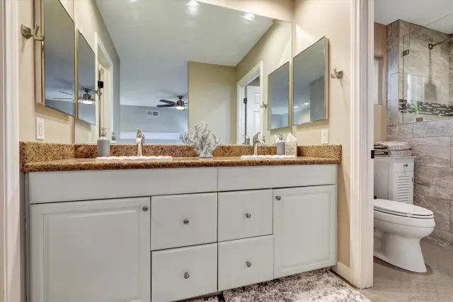 a bathroom with a granite countertop sink mirror and toilet