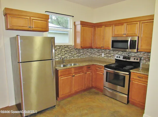 a kitchen with stainless steel appliances granite countertop a refrigerator stove and microwave