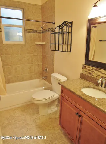 a bathroom with a granite countertop toilet sink and shower