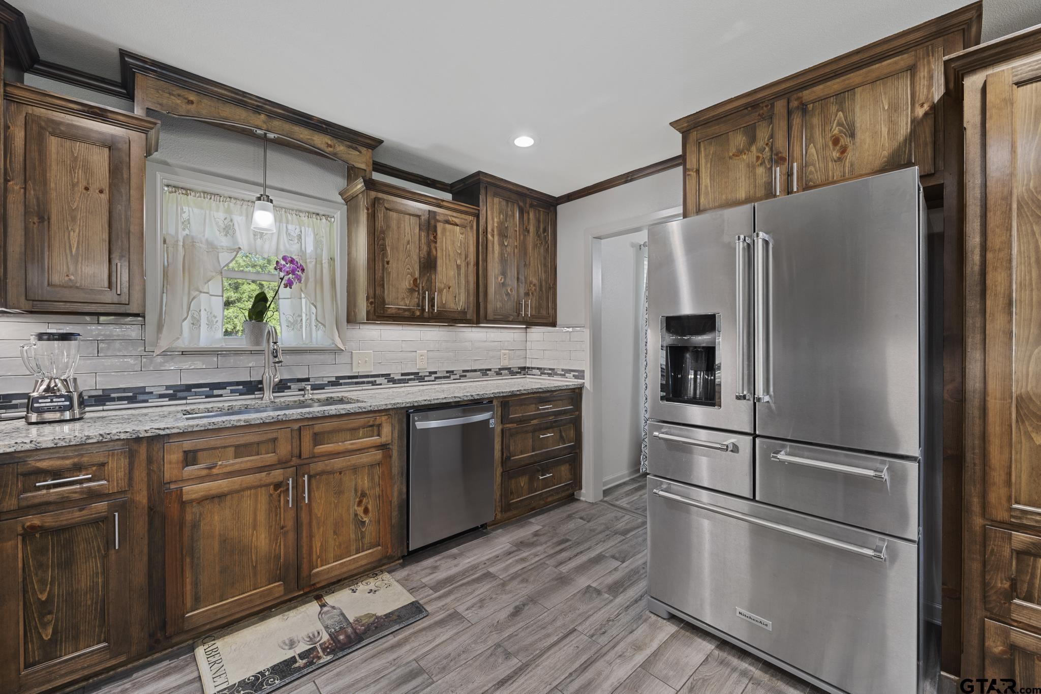 2201 Ridgley Tyler, TX 75703 - Photo 12 of 42 a kitchen with granite countertop stainless steel appliances a refrigerator sink and microwave