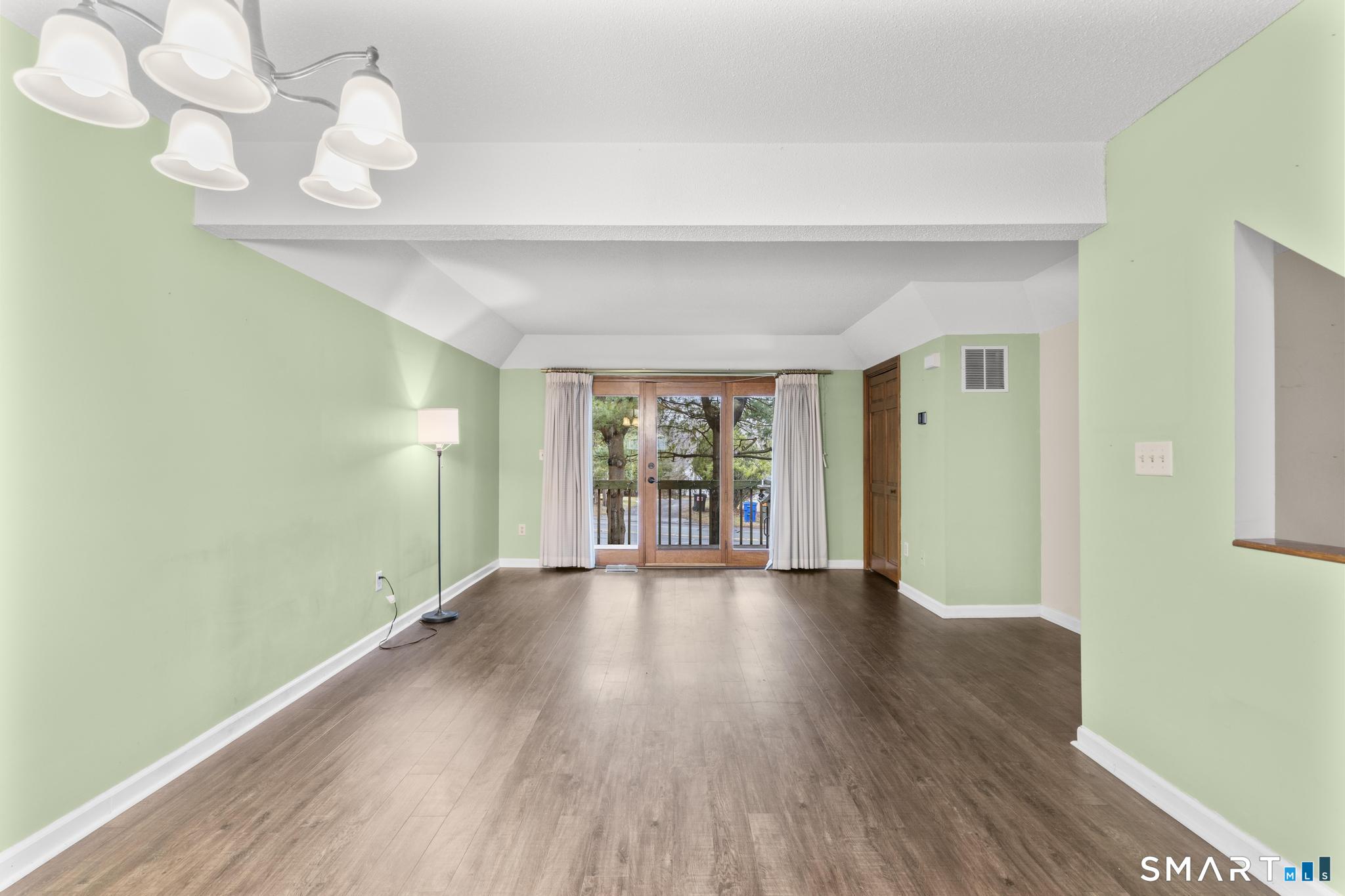 1655 North Colony Road, Unit 15 Meriden, CT 06450 - Photo 3 of 25 a view of an empty room with wooden floor and a window