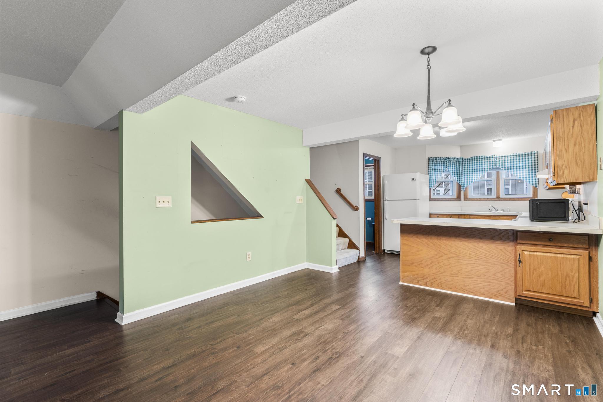 1655 North Colony Road, Unit 15 Meriden, CT 06450 - Photo 6 of 25 a view of a living room and kitchen with wooden floor