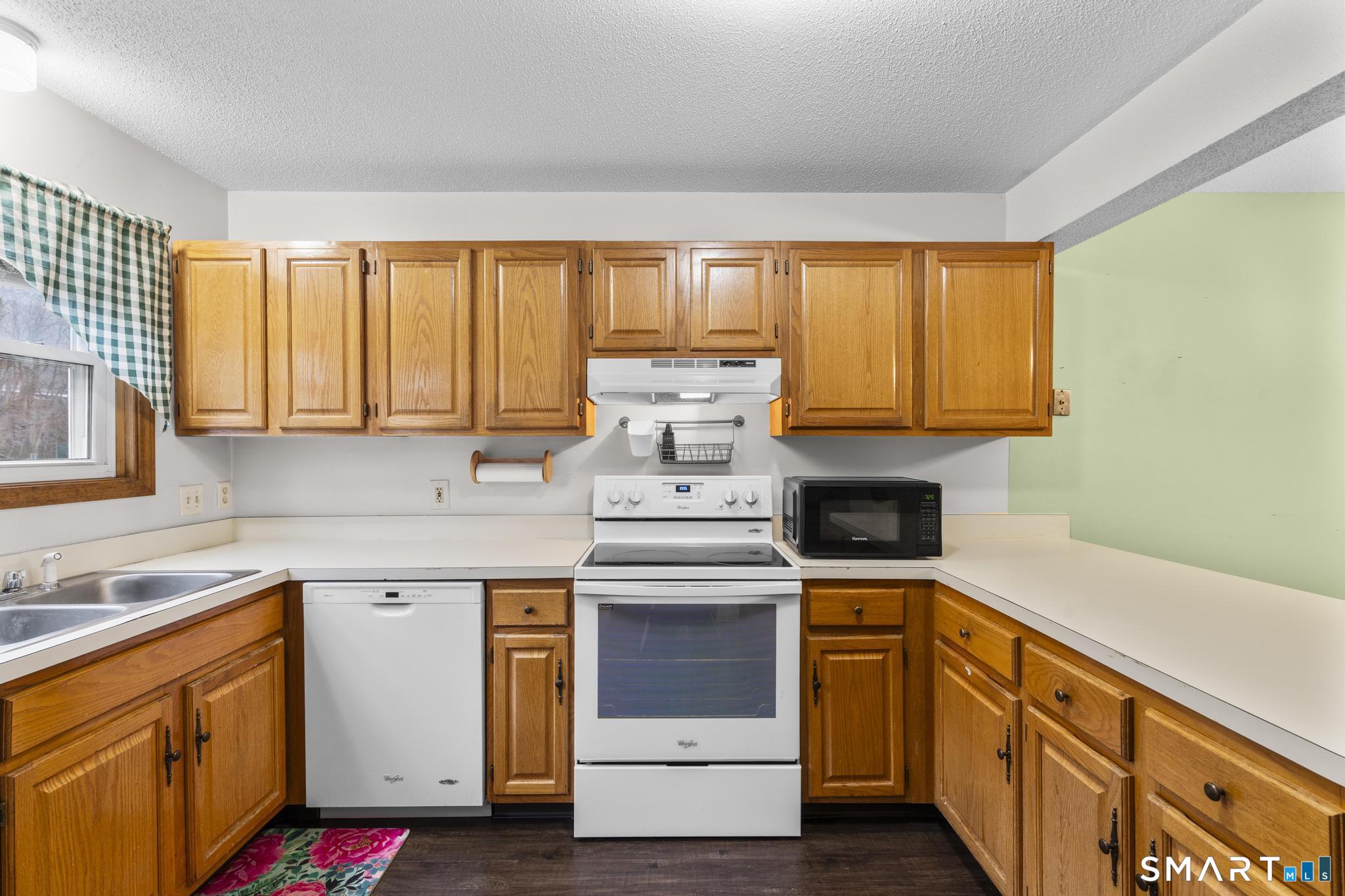 1655 North Colony Road, Unit 15 Meriden, CT 06450 - Photo 9 of 25 a kitchen with stainless steel appliances granite countertop a stove a sink and a microwave