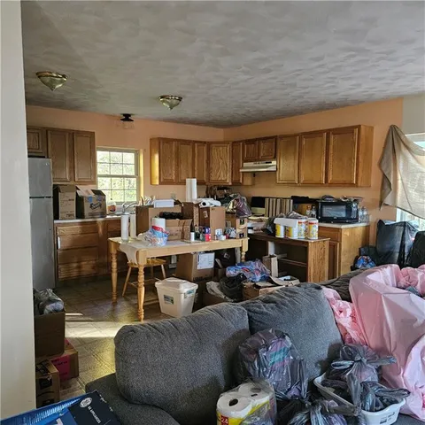 a living room with lots of furniture and a view of kitchen