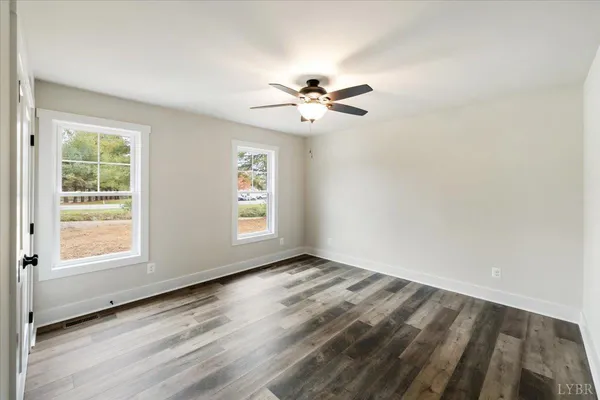 a view of empty room with wooden floor