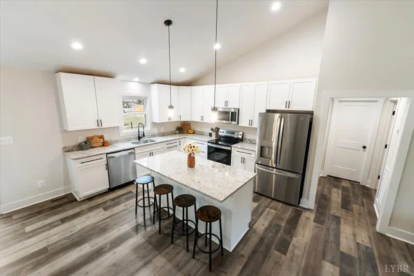 a large kitchen with kitchen island a stove a sink a dining table and chairs