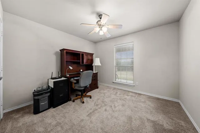 a view of a workspace with furniture and a window
