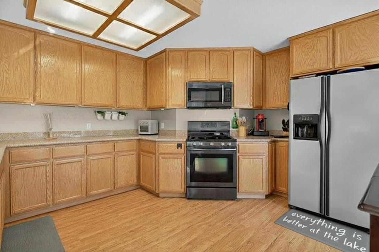 4856 Kiva Drive Copperopolis, CA 95228 - Photo 13 of 61 a kitchen with stainless steel appliances granite countertop a stove a sink dishwasher a refrigerator and a microwave