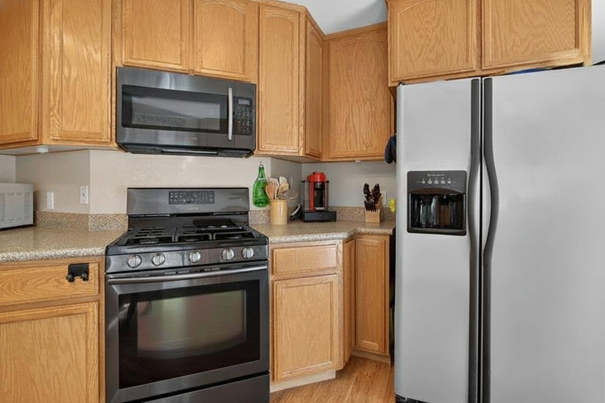 4856 Kiva Drive Copperopolis, CA 95228 - Photo 14 of 61 a kitchen with stainless steel appliances a stove a microwave and cabinets