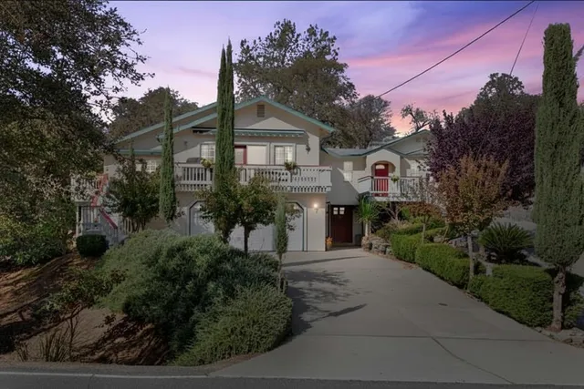 a front view of a house with a yard and trees