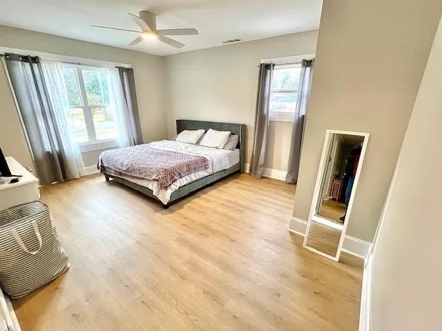 a bedroom with a bed and wooden floor