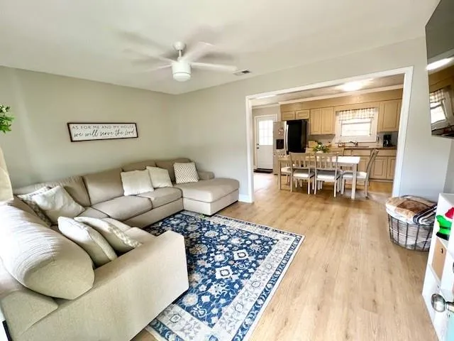 a living room with furniture and a wooden floor