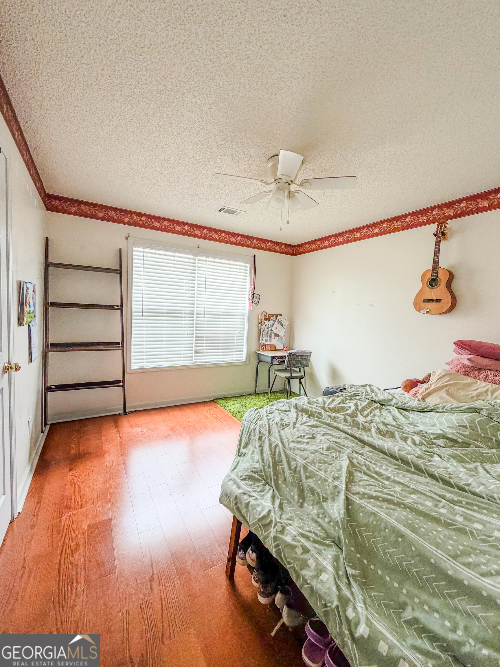 408 Mosby Lane Locust Grove, GA 30248 - Photo 12 of 17 a bed sitting in a bedroom next to a window