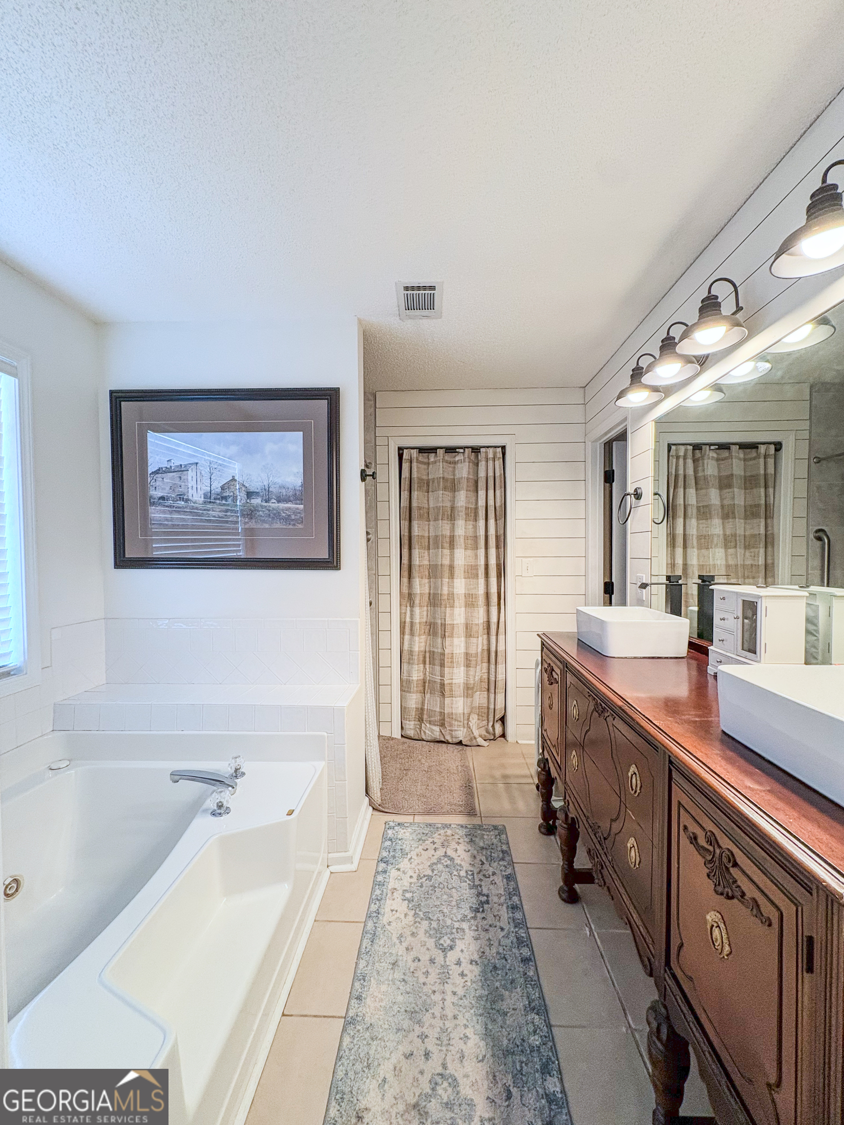 408 Mosby Lane Locust Grove, GA 30248 - Photo 10 of 17 a spacious bathroom with a tub sink and mirror