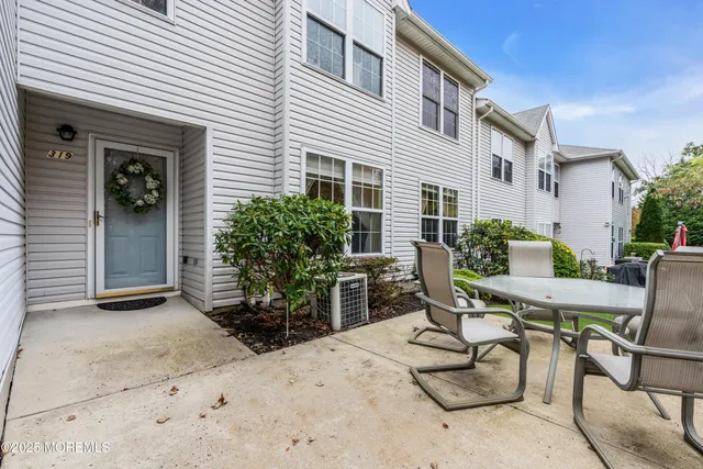 a view of backyard with seating space and wooden fence