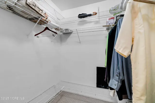 a view of walk in closet with clothes and shoes
