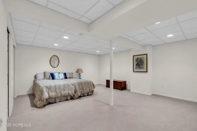 a spacious bedroom with a bed and a lamp