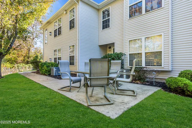 a view of a house with backyard and sitting area