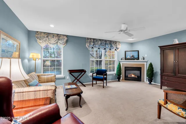 a living room with furniture a fireplace and a floor to ceiling window