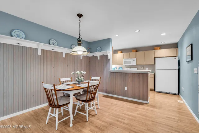 a kitchen with stainless steel appliances kitchen island granite countertop a table chairs and a refrigerator