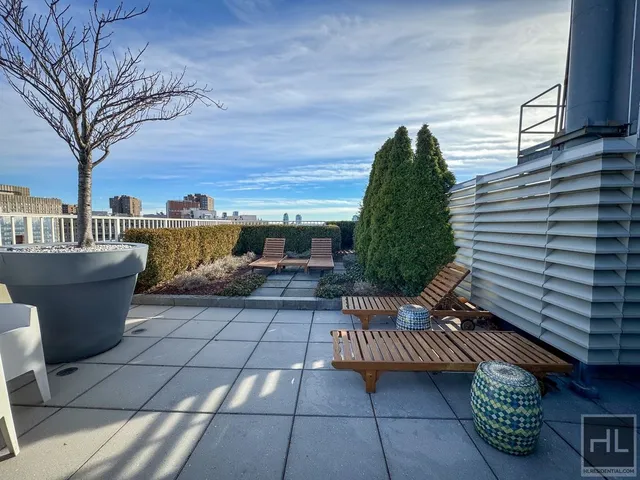 a view of a patio with couches and table and chairs with wooden floor and fence