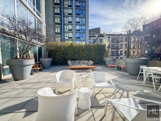 a view of a kitchen with furniture and stainless steel appliances