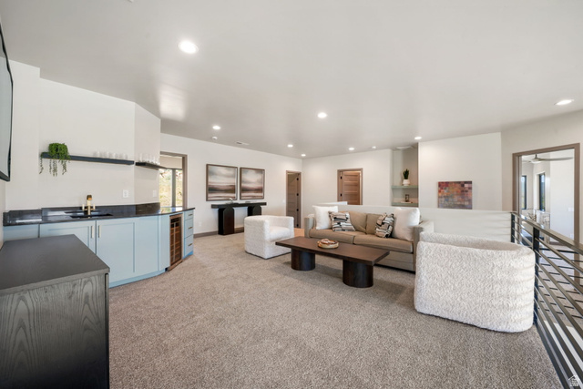 10646 North Reflection Ridge Hideout, UT 84036 - Photo 19 of 43 Spacious open-concept living area featuring a built-in wet bar with light blue cabinetry, a beverage refrigerator, and a gold-tone faucet