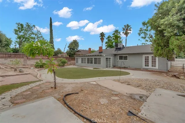 a view of a house with a backyard and a tree