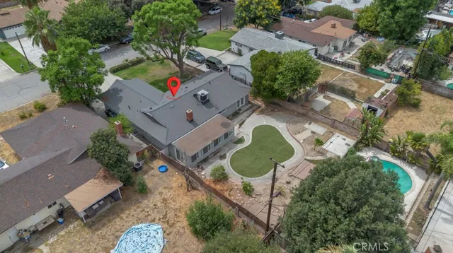 an aerial view of a house with a yard and greenery