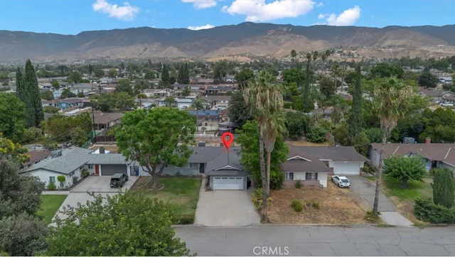 an aerial view of residential houses with outdoor space and a street view