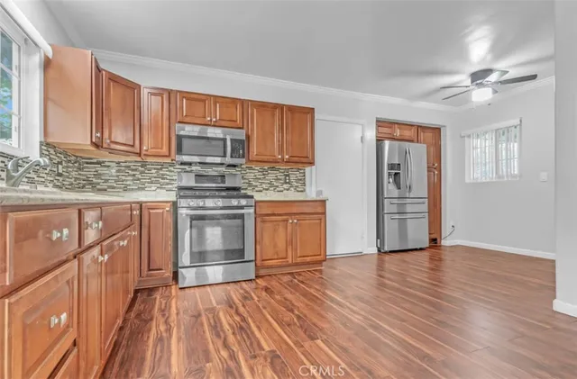 a kitchen with stainless steel appliances granite countertop a stove top oven and cabinets