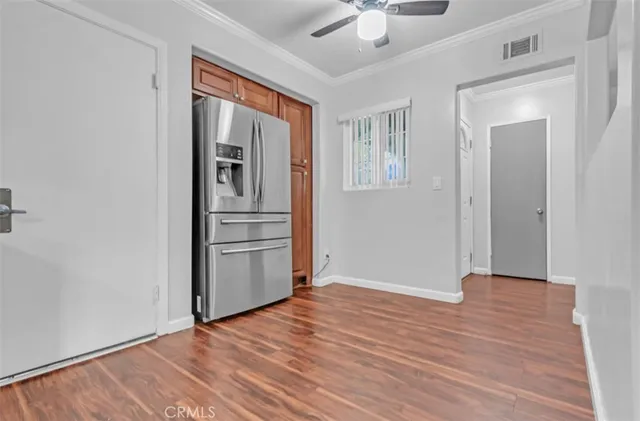 a view of empty room with wooden floor and ceiling fan