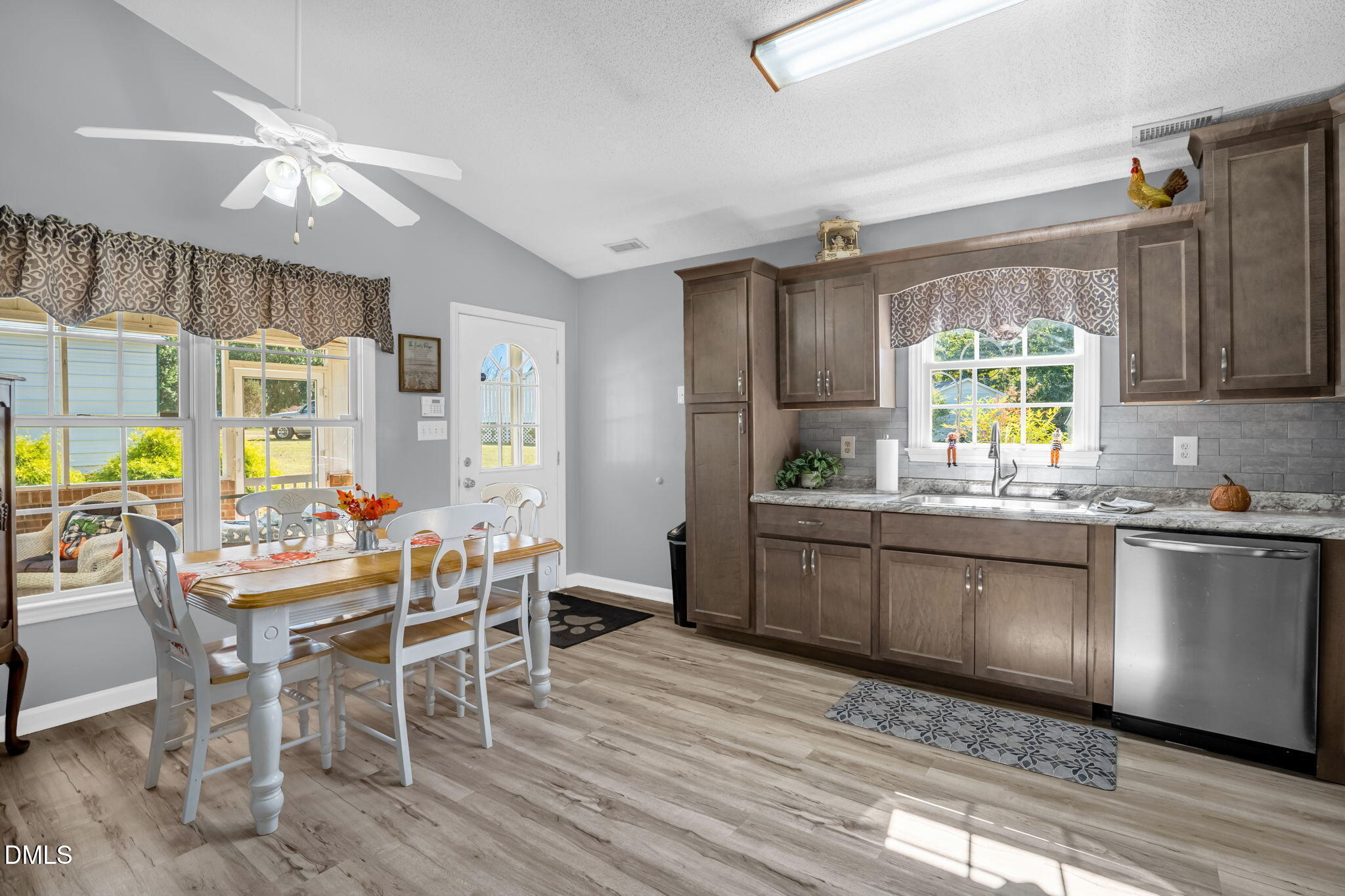 5626 Preston Loop Mebane, NC 27302 - Photo 17 of 33 a kitchen with stainless steel appliances granite countertop wooden floor dining table and chairs