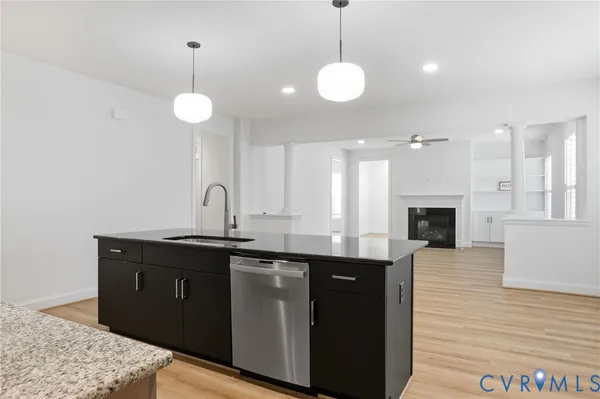 a kitchen with stainless steel appliances granite countertop a sink a stove and a wooden floors