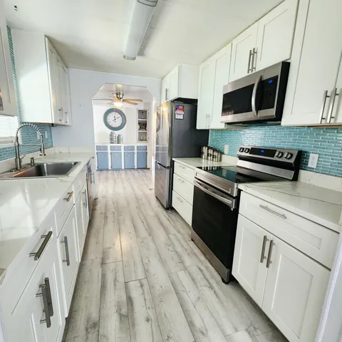 a living room with furniture and a potted plant on a dresser