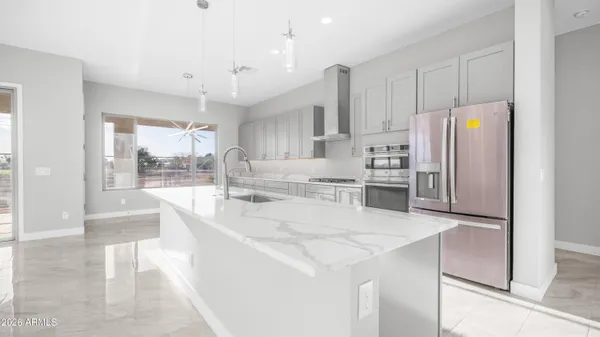 a large white kitchen with a large window a sink and stainless steel appliances