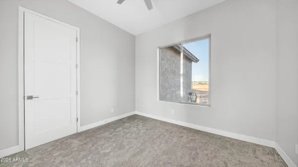 an empty room with windows and fan