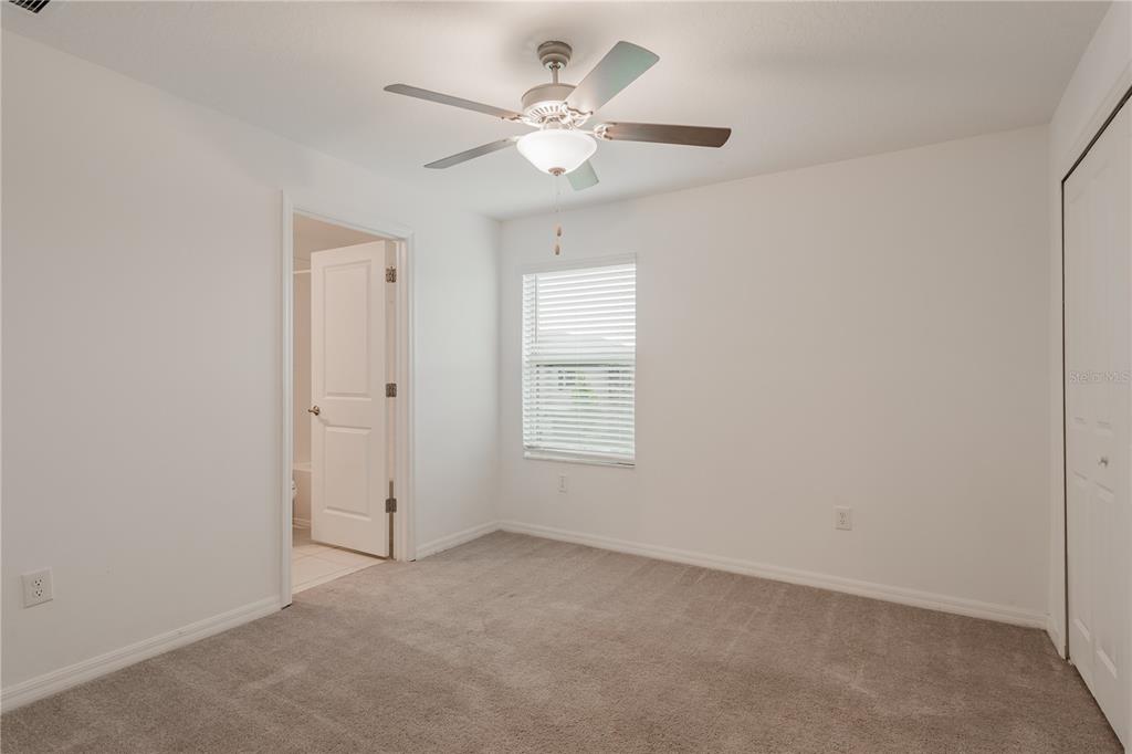 14302 Editors Note Street Ruskin, FL 33573 - Photo 11 of 44 an empty room with a chandelier fan and windows