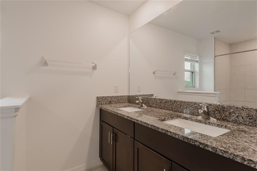 14302 Editors Note Street Ruskin, FL 33573 - Photo 12 of 44 a bathroom with a granite countertop sink and a mirror