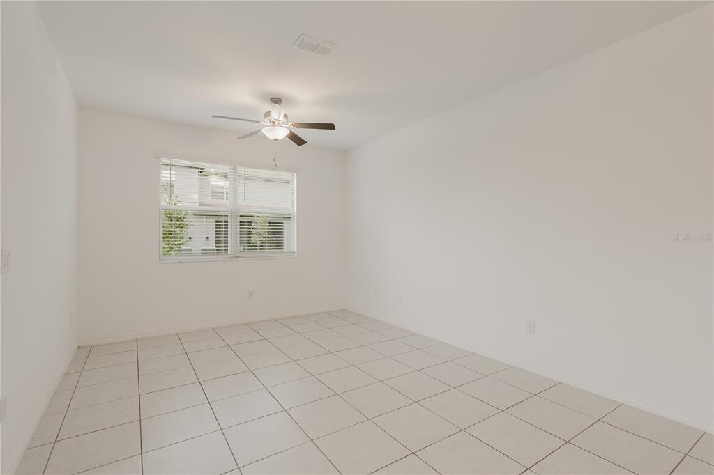 14302 Editors Note Street Ruskin, FL 33573 - Photo 24 of 44 an empty room with windows and ceiling fan