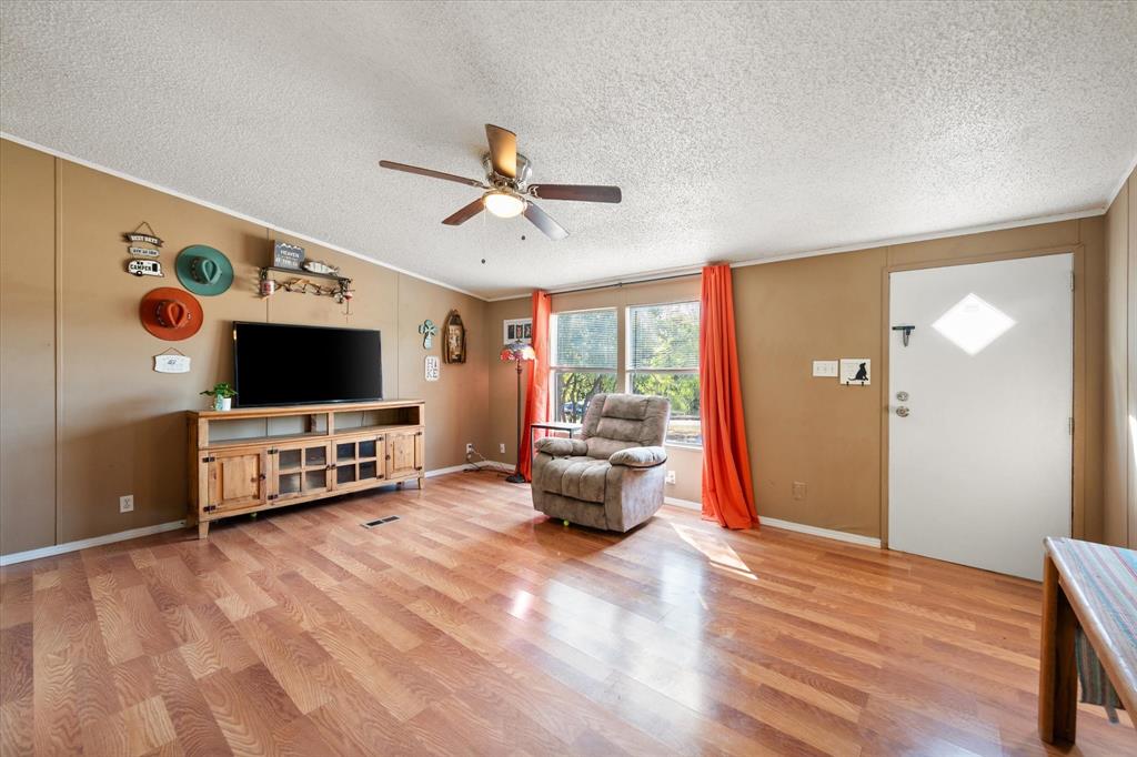 309 Southeast County Road Corsicana, TX 75109 - Photo 9 of 27 Wood-finish flooring throughout, ceiling fan with integrated lighting, and multiple windows providing natural illumination