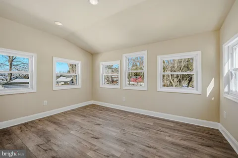 a view of empty room with window and wooden floor