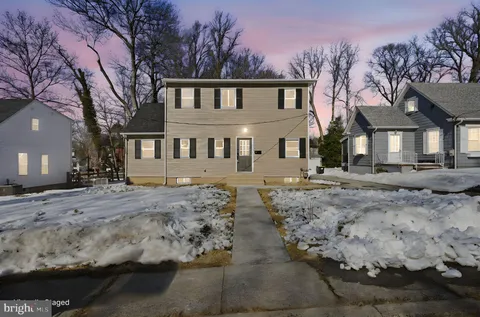a view of a white house with a yard covered in snow