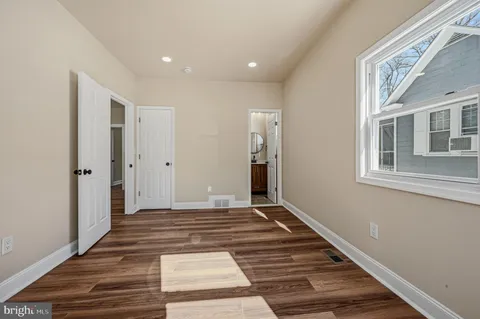 a view of a hallway with wooden floor and a window