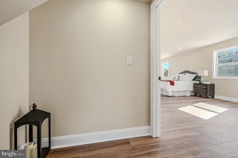 a view of a living room and bedroom with wooden floor