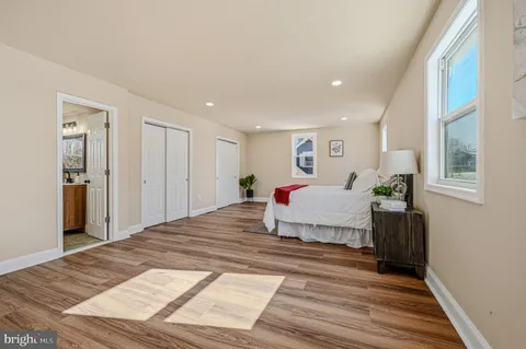 a spacious bedroom with a bed and a dresser