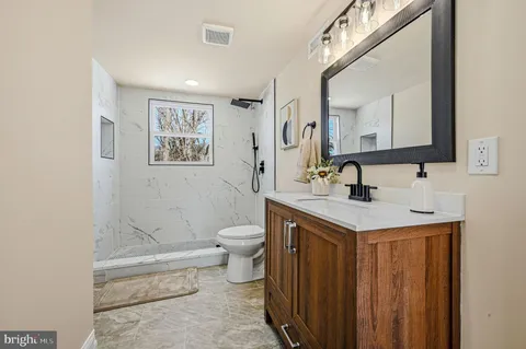 a bathroom with a sink a toilet and shower