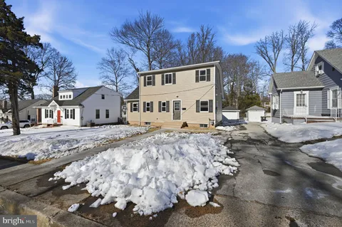 a view of a white house with a yard covered in snow