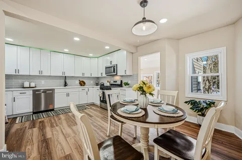 a kitchen with a dining table chairs stove top oven and microwave